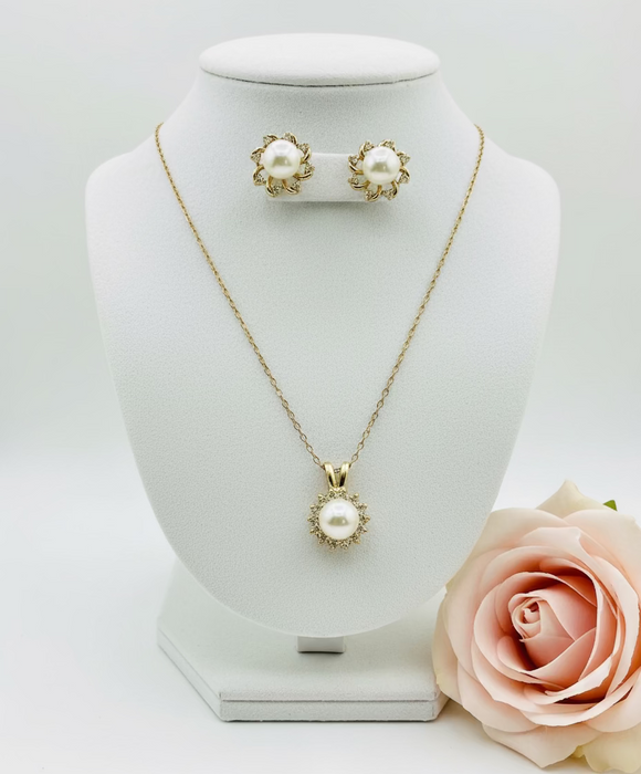 Pearl necklace and earrings on a clear stand with a rose in corner
